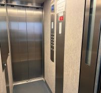 Elevator with metal doors and a control panel in a three-room apartment.