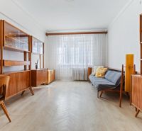 A living room in a 3-room apartment with a wooden decor floor and retro furniture.