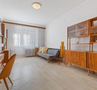 A room in a 3-room apartment with retro furniture and a wooden decor floor.