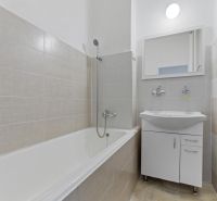 A bathroom with a bathtub, white sink, and mirror in a 3-room apartment.