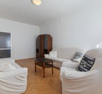 Living room with a sofa and a wooden decor floor in a 3-room apartment.