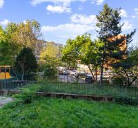 Garden with a playground, greenery surrounded by apartment buildings on Tabakova Street in Bratislava.