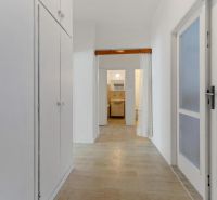 A hallway in a 3-room apartment with storage spaces and a floor with a wooden decor.