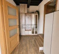 A hallway with stairs and a wooden decor floor in a family house.