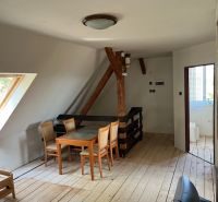 Interior of a family house with a dining table and chairs on a floor with a wooden decor.