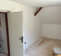 A room in a family house with a wooden decor floor and open doors.