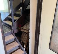 A staircase in a family house with storage space under the stairs, with glass doors.