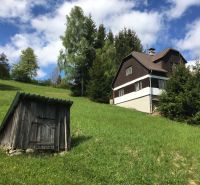 A family house in Korňa on Korňa Street surrounded by a green meadow and trees.