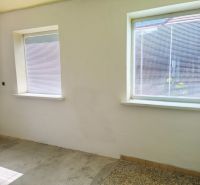 Walls and windows of a room with a concrete floor and blinds in a family house.