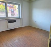 A room in a family house with a window, a light fixture, and a floor with a wooden decor.