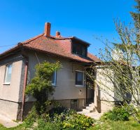A family house in Zlaté Moravce with a red sloped roof and a landscaped garden.