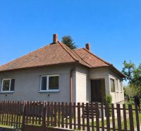 A family house in Zlaté Moravce with a sloped roof and a fence in the foreground.