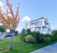 Modern architecture of a 2-room apartment in Malinovo surrounded by greenery and blue skies.