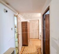 A hallway in a family house with rustic tiles and wooden furniture.