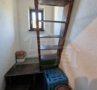 Attic stairs in a family house with a wood decor and a window.