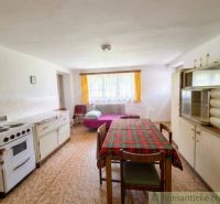 Interior of a family house with a kitchen unit and a dining table, floor with wooden decor.