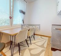 A kitchen in a 2-room apartment with a dining table and a floor with a wooden decor.