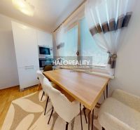 A kitchen in a 2-room apartment with a wooden decor floor and natural lighting.