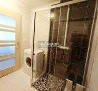 A bathroom in a 2-room apartment with a washing machine and a shower.