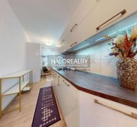 A kitchen unit with decorative tiles, a shelf, and a wooden decor floor in a 2-room apartment.
