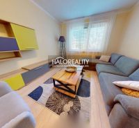 Living room in a two-room apartment with a wooden decor floor and a colorful set.