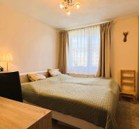 A bedroom in a 3-room apartment with a double bed and a window with curtains.