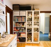 3-room apartment with shelves for books, games, and dishes, wooden floor decor.
