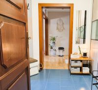 Entrance hall in a 3-room apartment with tiled floor, decor, and furniture.