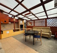 Covered terrace with seating and grill at the cottage in Svinica.
