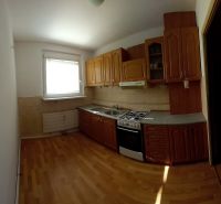 A kitchen in a 3-room apartment with a kitchen unit and a floor with a wooden decor.