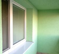 Glazed loggia in a 3-room apartment with tiles and a green wall.