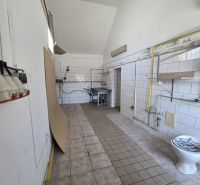 A white room in a gastro area with light tiles and sanitary equipment.