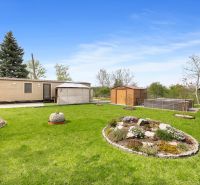 A landscaped garden with a mobile home, gazebo, and storage space in Hurbanovo.