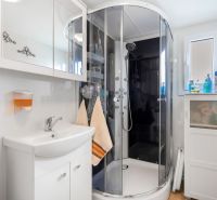 Bathroom in a cabin with a modern shower, sink, and storage space.
