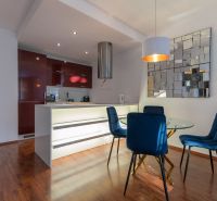 A stylish kitchen with wood-effect flooring in a 2-room apartment.