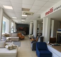 Interior of commercial spaces with displayed furniture, sofas, and armchairs.