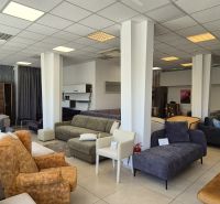 Commercial premises with sofas and armchairs and a floor with a wooden decor.