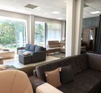Sofas and armchairs in commercial spaces with large windows and wood-patterned flooring.