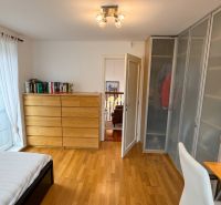 A bedroom in a family house with a wooden decor floor and a wardrobe.