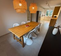 Dining area with wood-patterned flooring and rattan lamps in a family house.