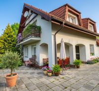A family house in Sliač with a terrace, garden furniture, and a colorful garden.