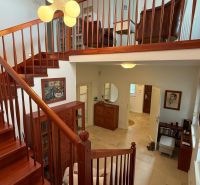 A staircase with a wooden railing and an entrance hall in a family house.