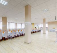 A large room with white tables and chairs, a floor with a wooden decor, and decorations.