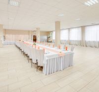 A large hall with decorated tables and a wooden-patterned floor for commercial purposes.
