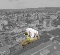 A building of commercial premises on Jána Zigmundíka Street in Vrbové surrounded by greenery.