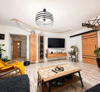 Living room with wood-patterned flooring and wooden furniture in a family house.