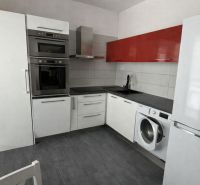 The kitchen of a 4-room apartment with an L-shaped kitchen unit, an oven, and a washing machine.