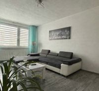 Living room in a 4-room apartment with a large sofa and a floor with a wooden decor.
