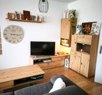 Living room in a 4-room apartment with a sofa, decorations, and a floor with a wooden design.