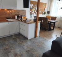 A kitchen in a 4-room apartment with wood decor and a comfortable dining nook.